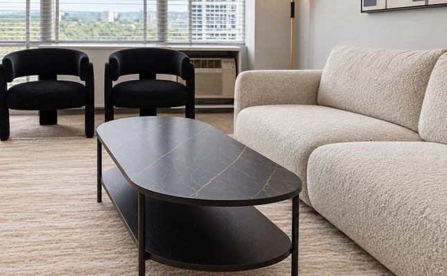 ADRESA living room with cream boucle sofa, black marble coffee table, and city views